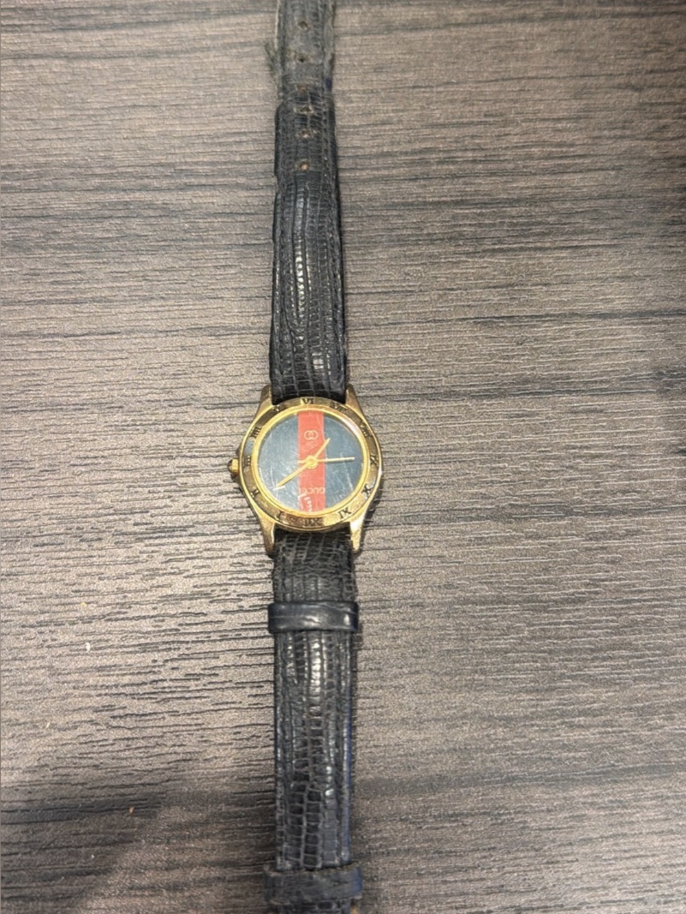 Gucci women’s Black Leather Strap Watch with Gold Case and Red-Blue Stripe Dial